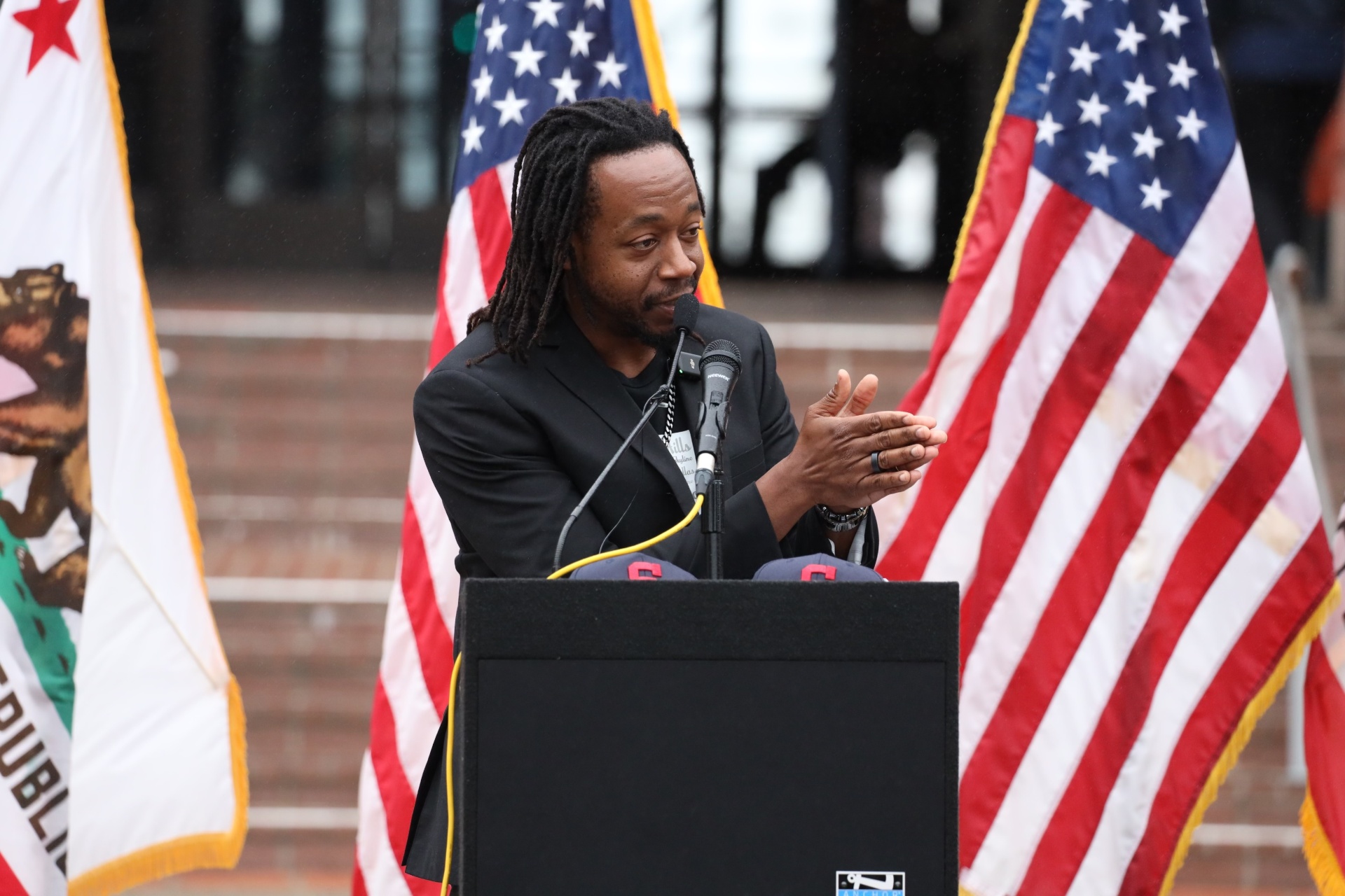 Tommy Walker speaking at podium with American flags